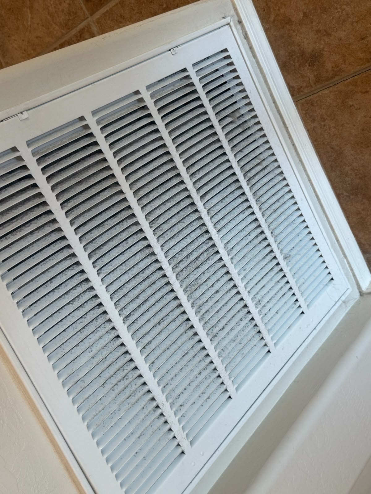 Air return vent covered in dust before cleaning