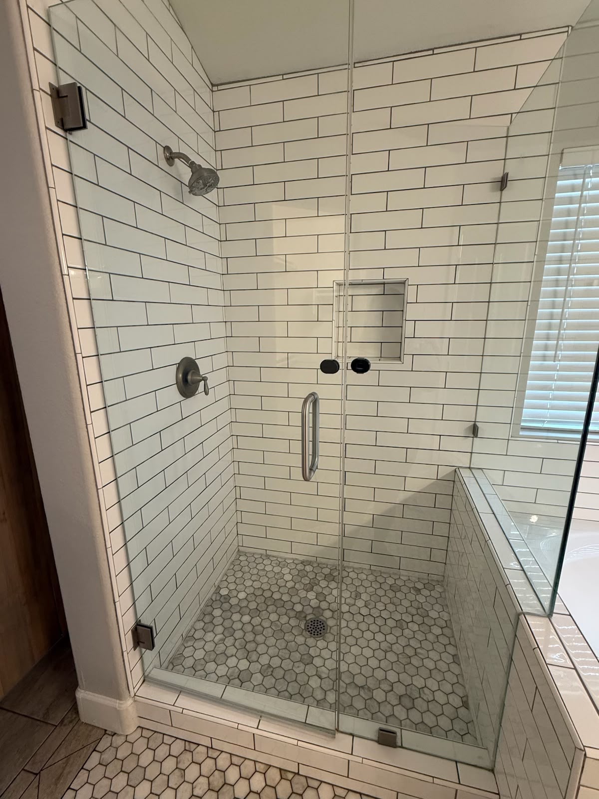 Walk in shower with clean tile and clear glass after cleaning