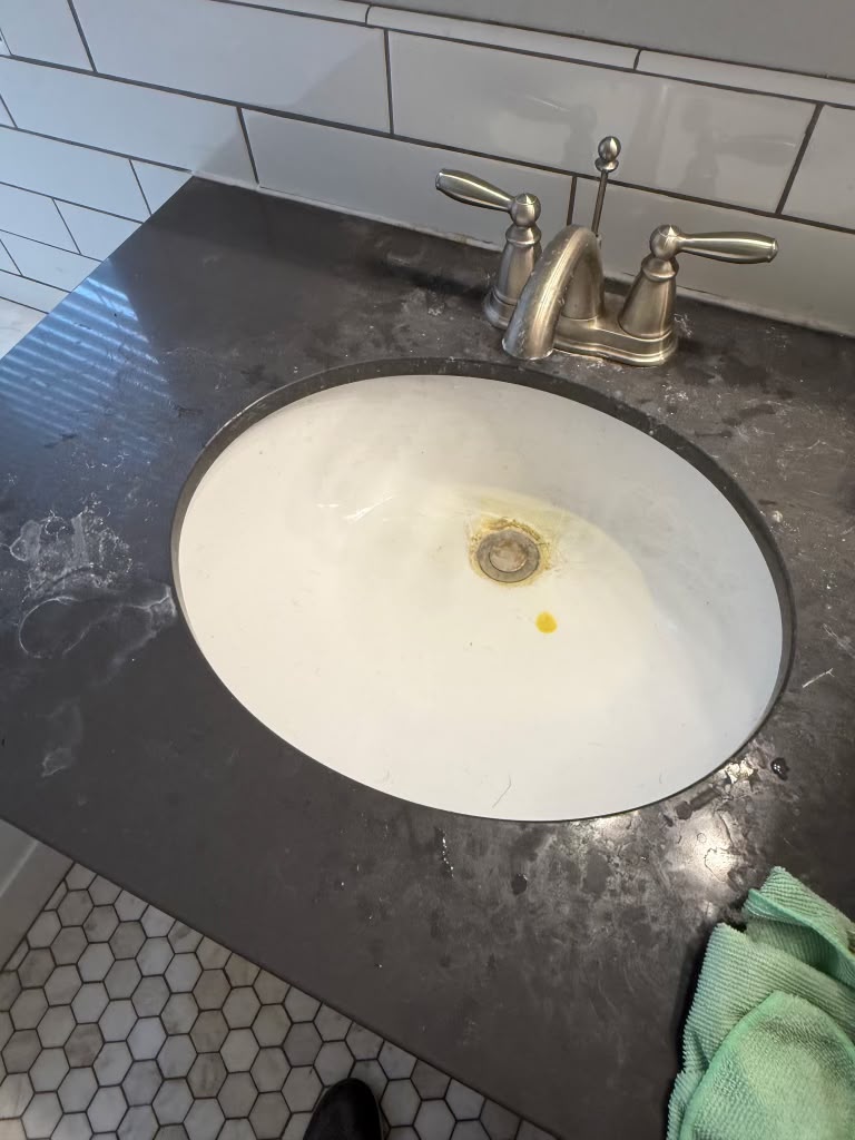 Bathroom vanity sink with water spots and stains before cleaning